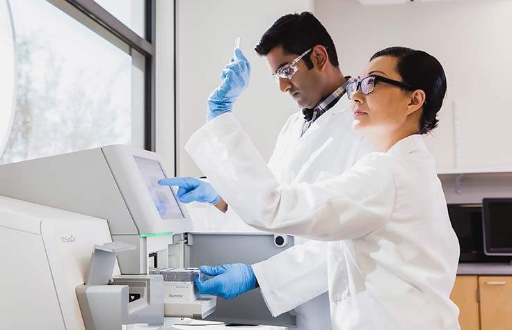 two people in lab using Illumina sequencer
